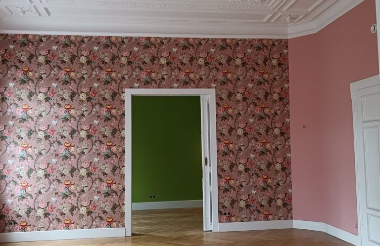 Blumige Tapete und grüne Wand